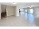 View of a bright living room highlighting tile floors, stairs, and an open-concept layout to the kitchen at 4456 Globe Thistle Dr, Tampa, FL 33619