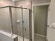 Bathroom shower featuring tiled walls, glass door, and a built in shelf for supplies at 4456 Globe Thistle Dr, Tampa, FL 33619