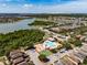Scenic aerial view of the community pool, playground and basketball court with a lake backdrop at 4516 Savannah Holly Pl, Riverview, FL 33578