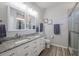 Bright bathroom featuring double sinks, granite countertop, and a glass-enclosed shower at 4516 Savannah Holly Pl, Riverview, FL 33578