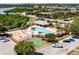 Aerial view of the community pool, playground, and basketball court surrounded by lush landscaping and ample parking at 4516 Savannah Holly Pl, Riverview, FL 33578