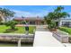 Backyard view showcasing dock and inviting pool with multiple patio doors surrounded by greenery at 4935 58Th S Ave, St Petersburg, FL 33715