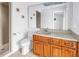 Well-lit bathroom with cherry cabinets, solid-surface countertop, and shower access at 4935 58Th S Ave, St Petersburg, FL 33715