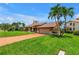Beautiful exterior view of the home with a large well-manicured lawn, tropical landscaping, and driveway at 4935 58Th S Ave, St Petersburg, FL 33715