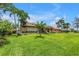 Beautiful exterior view of the home with a large well-manicured lawn and tropical landscaping at 4935 58Th S Ave, St Petersburg, FL 33715