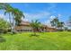 Beautiful exterior view of the home with a large well-manicured lawn and tropical landscaping at 4935 58Th S Ave, St Petersburg, FL 33715