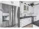 Well-equipped kitchen featuring stainless steel refrigerator and stylish white cabinetry at 4935 58Th S Ave, St Petersburg, FL 33715