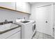 Clean laundry room with sink, granite countertops, and white washer/dryer at 4935 58Th S Ave, St Petersburg, FL 33715
