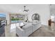 Bright living room featuring tile floors, a modern sofa, and large windows overlooking the pool and canal at 4935 58Th S Ave, St Petersburg, FL 33715