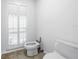 Small toilet room featuring travertine floors, toilet, bidet, and a shuttered window at 4935 58Th S Ave, St Petersburg, FL 33715