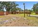 Backyard with storage and fencing with mature trees and grass at 5306 Downing St, Dover, FL 33527