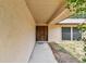 Covered entryway leading to a solid wooden front door with textured walls and window at 5306 Downing St, Dover, FL 33527