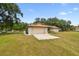 Home exterior with neutral paint and two-car garage with a yard at 5306 Downing St, Dover, FL 33527