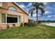 Manicured lawn in backyard with a tranquil water view and a decorative half moon window at 542 Princeton Greens Ct # 21, Sun City Center, FL 33573