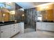 An open-concept bathroom with a double vanity, glass shower, and neutral tile throughout at 542 Princeton Greens Ct # 21, Sun City Center, FL 33573