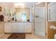 A well-lit bathroom features white cabinets, a granite countertop, and a glass-enclosed shower at 542 Princeton Greens Ct # 21, Sun City Center, FL 33573