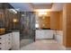 Bright bathroom boasting a glass enclosed shower, black countertop, vanity and soaking tub with custom tile work at 542 Princeton Greens Ct # 21, Sun City Center, FL 33573