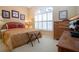 Comfortable bedroom featuring a large window, patterned bedspread, and decorative wall art at 542 Princeton Greens Ct # 21, Sun City Center, FL 33573