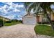 Paver driveway leads to the home's garage with a well-maintained lawn and landscaping at 542 Princeton Greens Ct # 21, Sun City Center, FL 33573