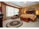 Spacious main bedroom with a large bed, custom window treatments and an area rug at 542 Princeton Greens Ct # 21, Sun City Center, FL 33573