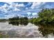 Scenic view of a tranquil pond reflecting the cloudy sky and surrounding trees at 542 Princeton Greens Ct # 21, Sun City Center, FL 33573