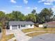 Aerial view showcases the home with a grey roof, attached garage, and large yard at 5628 Mccoy Ct, Zephyrhills, FL 33542