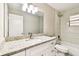 Bathroom featuring a white vanity with granite countertop, framed mirror and tiled shower/tub at 5628 Mccoy Ct, Zephyrhills, FL 33542
