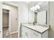 Updated bathroom featuring a white vanity with granite countertop, framed mirror and views into the hall at 5628 Mccoy Ct, Zephyrhills, FL 33542