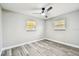Well lit bedroom featuring a ceiling fan, wood floors, and bright windows at 5628 Mccoy Ct, Zephyrhills, FL 33542