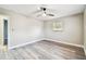 Bedroom with wood-look flooring and a window showing neutral paint and white trim at 5628 Mccoy Ct, Zephyrhills, FL 33542