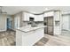 Open kitchen boasts an island, stainless appliances, and modern white cabinets at 5628 Mccoy Ct, Zephyrhills, FL 33542