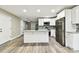 Open kitchen features an island, stainless appliances, and modern white cabinets at 5628 Mccoy Ct, Zephyrhills, FL 33542