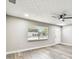 Living room with a window and fan showing neutral paint and plank flooring at 5628 Mccoy Ct, Zephyrhills, FL 33542