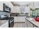 Modern kitchen with stainless steel appliances, gray backsplash and ample counter space at 5743 Skytop Dr, Lithia, FL 33547