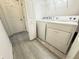 Bright laundry room with washer, dryer, shelving and tile flooring at 5743 Skytop Dr, Lithia, FL 33547