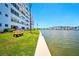 Scenic waterfront view showing green grass and building under a clear blue sky at 5925 Shore S Blvd # 611, Gulfport, FL 33707