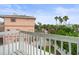 Overlooking the surroundings from the balcony, showcasing the nearby building and tropical vegetation at 619 2Nd St # 3, Indian Rocks Beach, FL 33785