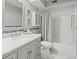 Clean bathroom with a marble vanity, white toilet, and shower with patterned curtains at 619 2Nd St # 3, Indian Rocks Beach, FL 33785