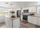 Well-lit kitchen with white cabinets, stainless steel appliances, and a view from the window over the sink at 619 2Nd St # 3, Indian Rocks Beach, FL 33785