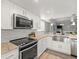 Bright kitchen featuring stainless steel appliances, updated cabinets, a large sink and granite countertops at 619 2Nd St # 3, Indian Rocks Beach, FL 33785