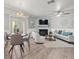 Open-concept living space with dining area, stone fireplace, and modern decor at 619 2Nd St # 3, Indian Rocks Beach, FL 33785