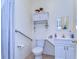 Well-lit bathroom with a toilet, grab bar, white vanity, storage and a framed mirror at 6612 N Orleans Ave, Tampa, FL 33604