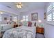 Well decorated bedroom with chandelier, large mirrored closet, two side tables and two windows at 6612 N Orleans Ave, Tampa, FL 33604