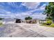 Full exterior shot of the property with a detached garage, carports, covered patio, and mature landscaping at 6612 N Orleans Ave, Tampa, FL 33604