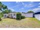 Side exterior showcases the well-maintained yard and carport, complemented by classic black shutters at 6612 N Orleans Ave, Tampa, FL 33604