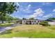 Charming single-story home features a well-manicured lawn and welcoming carport, with traditional shutters at 6612 N Orleans Ave, Tampa, FL 33604