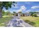 Inviting front exterior features a cozy carport and lush lawn, perfect for enjoying outdoor living at 6612 N Orleans Ave, Tampa, FL 33604