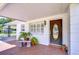 Cozy front porch with brick flooring, complete with a bench and a covered carport for added convenience at 6612 N Orleans Ave, Tampa, FL 33604