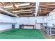 Spacious garage featuring exposed rafters, workbenches, white cabinets, and a painted floor at 6612 N Orleans Ave, Tampa, FL 33604