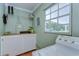 Laundry room featuring a white front load washer/dryer, work area, shelving and a window at 6612 N Orleans Ave, Tampa, FL 33604